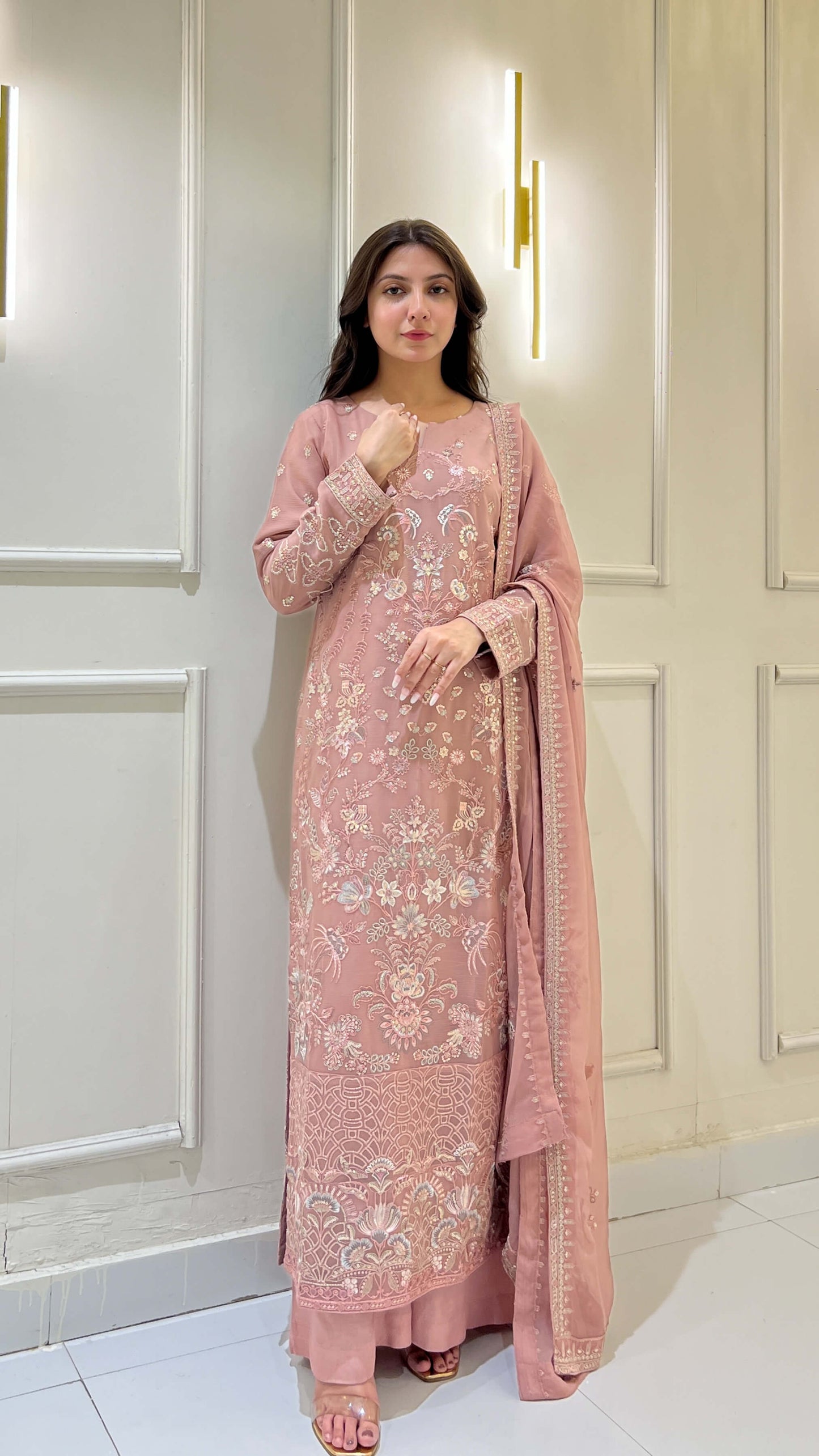 Woman posing in tea pink embroidered chiffon shalwar kameez