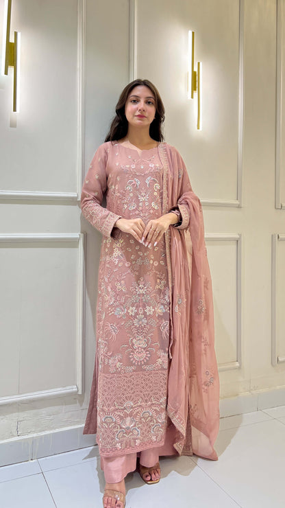 Woman wearing festive tea pink embroidered chiffon shalwar kameez suit