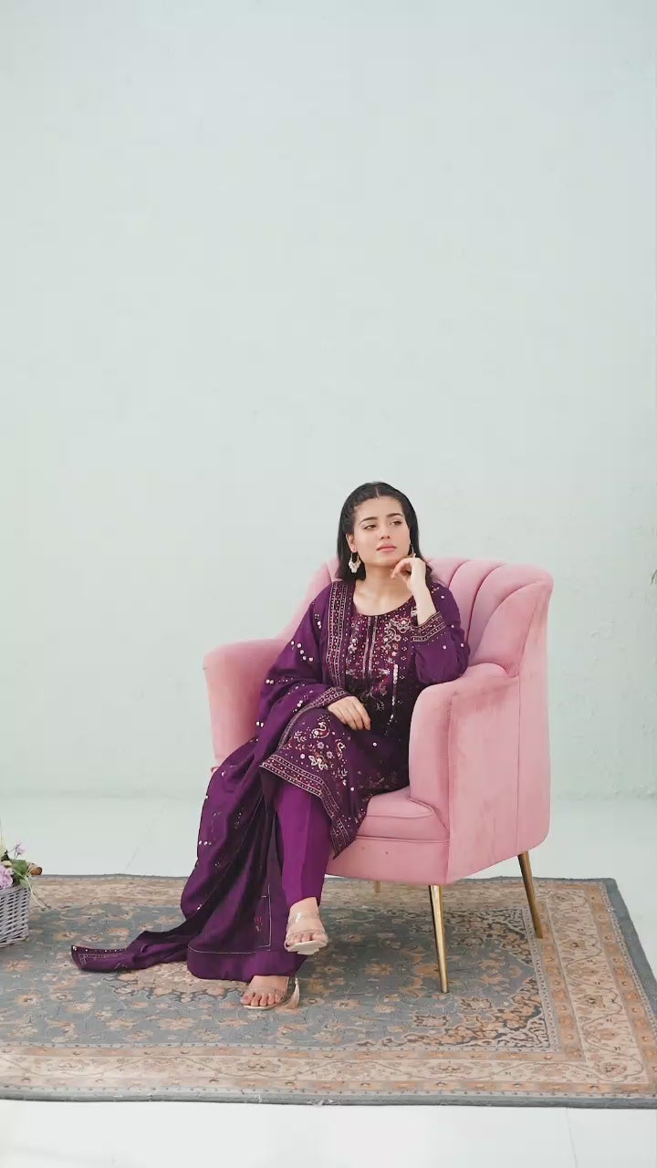 Model showcasing purple raw silk embroidered shalwar kameez set with elegant poses, embroidery highlights, and flowing dupatta styling.